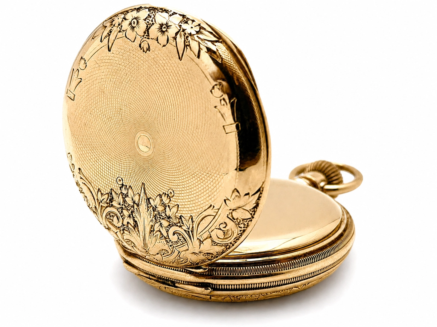 Gold pocket watch case open, showing ornate floral engraving on cover and engine-turned dial inside.