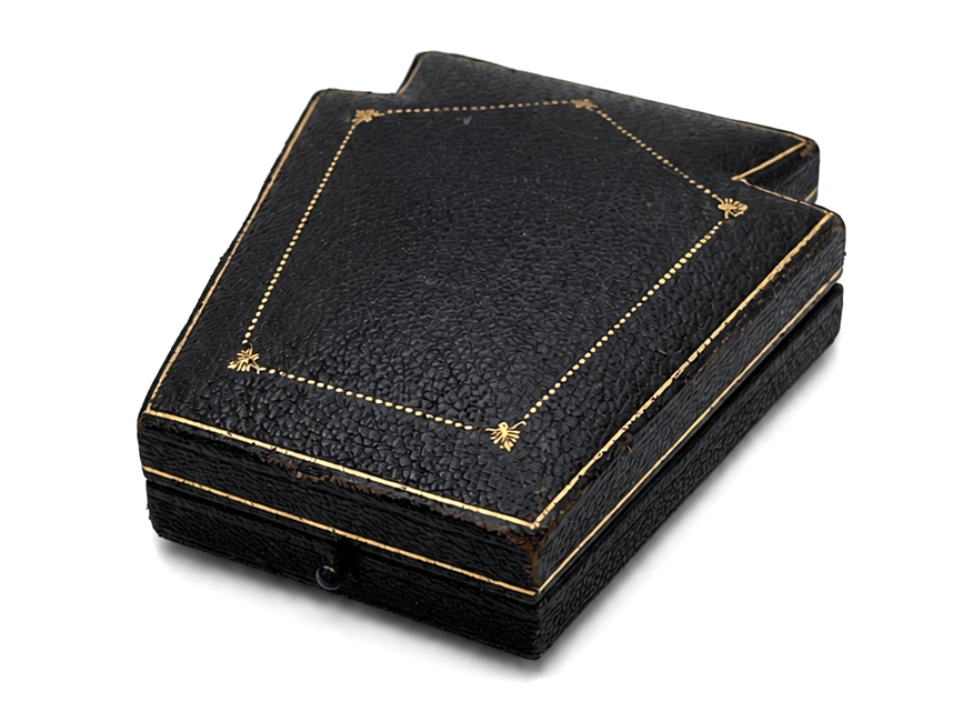 Black leather watch presentation box with gold gilt dotted border detailing and corner ornaments.