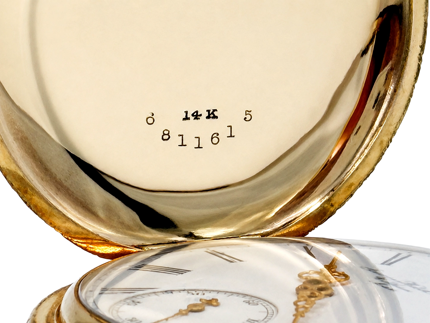 Case back interior showing 14K gold hallmark and serial number stamped on white enamel.